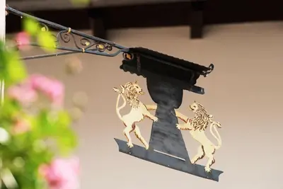 a sign with animals on it hanging on a building at L'GROF - AL CONTE in San Martino in Badia