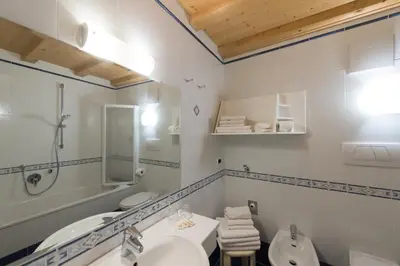 a bathroom with a sink and a toilet and a tub at L'GROF - AL CONTE in San Martino in Badia