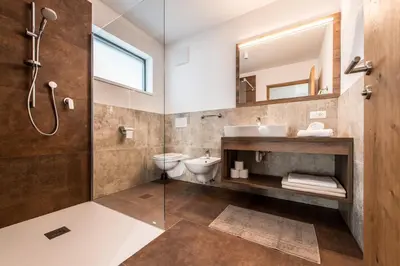 a bathroom with a sink toilet and a mirror at Chalet Kristall - Dolomites Garden Chalet in Falzes