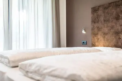 two white beds in a room with a window at Chalet Kristall - Dolomites Garden Chalet in Falzes