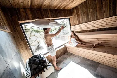 a man and a woman in a sauna at Chalet Kristall - Dolomites Garden Chalet in Falzes