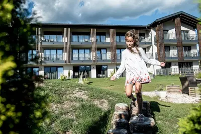 a young girl standing on a rock in front of a building at Chalet Kristall - Dolomites Garden Chalet in Falzes