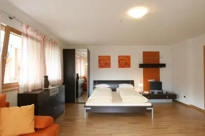 a bedroom with a bed and a couch in it at Klimahaus Dep. La Fradora in San Cassiano