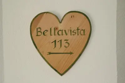 a wooden heart shaped clock on a wall at Klimahaus Dep. La Fradora in San Cassiano