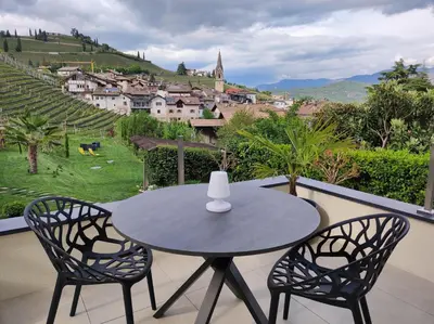 a table and two chairs on a balcony with a view at Zilli Studio Apartments in Termeno