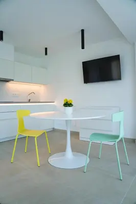 a kitchen with a white table and two chairs at Zilli Studio Apartments in Termeno