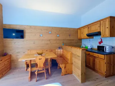a bedroom with a large bed and a table at Valles Vacanze - ski in & ski out in Falcade
