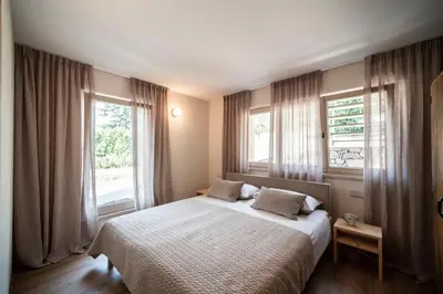 a bedroom with a bed and two windows at Weingut Kornell - Schafferhaus Cosmas und Zeder in Terlano