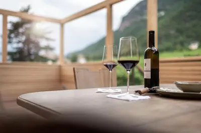 a table with two wine glasses and a bottle of wine at Weingut Kornell - Schafferhaus Cosmas und Zeder in Terlano