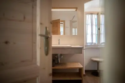 a bathroom with a sink and a mirror at Weingut Kornell - Schafferhaus Cosmas und Zeder in Terlano