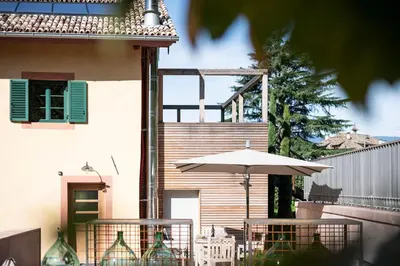 a patio with a table and an umbrella at Weingut Kornell - Schafferhaus Cosmas und Zeder in Terlano
