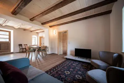 a living room with a couch and a tv and a table at Weingut Kornell - Schafferhaus Cosmas und Zeder in Terlano
