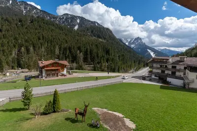 a green field with two deer in the grass next to a road at Chalet Butterfly 1 in Mazzin