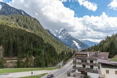 a road with a building and mountains in the background at Chalet Butterfly 1 in Mazzin