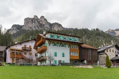 a large building in a field with a mountain at Chalet Butterfly 1 in Mazzin