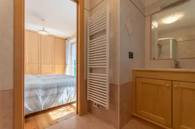 a bathroom with a bed and a sink and a mirror at Chalet Butterfly 2 in Mazzin