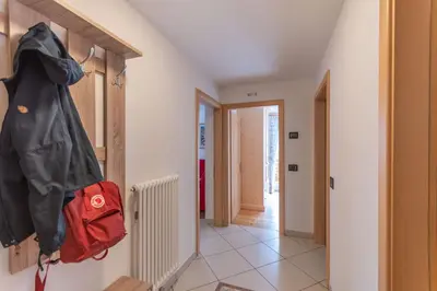 a hallway with a red bag hanging on a wall at Chalet Butterfly 2 in Mazzin
