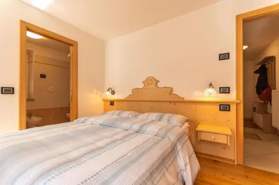a bedroom with a large bed and a bathroom at Chalet Butterfly 2 in Mazzin