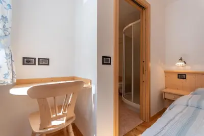 a bathroom with a sink and a shower next to a bed at Chalet Butterfly 2 in Mazzin