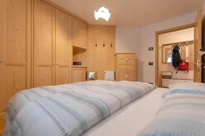 a large bed in a room with wooden cabinets at Chalet Butterfly 2 in Mazzin