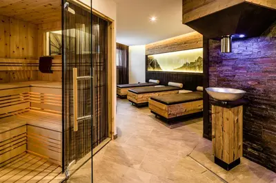 a sauna with a sink and two beds at Apartments Hotel Garden in Selva di Val Gardena