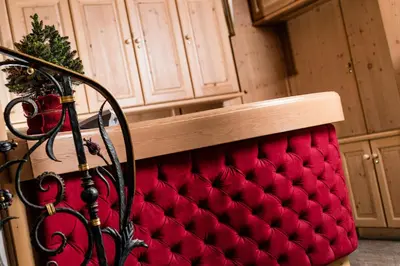 a red bench with a christmas tree on top of it at Apartments Hotel Garden in Selva di Val Gardena