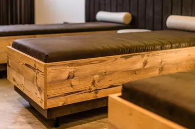 two wooden ottomans with brown seats in a room at Apartments Hotel Garden in Selva di Val Gardena