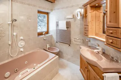 a bathroom with a tub and a toilet and a sink at Apartments Hotel Garden in Selva di Val Gardena