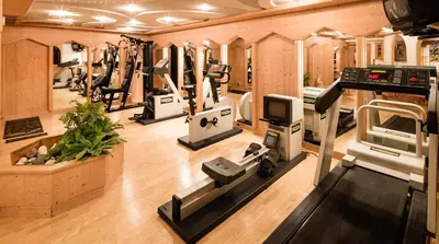 a gym with several treadmills and machines in it at Apartments Villa Gardena - Gardenahotels in Selva di Val Gardena