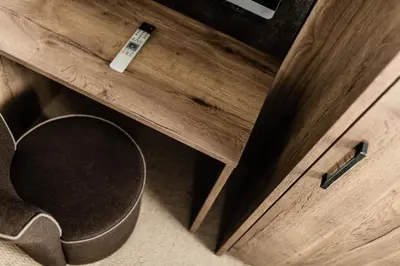 a wooden dresser with a trash can next to a drawer at Apartments Villa Gardena - Gardenahotels in Selva di Val Gardena
