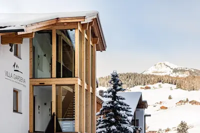 a house with a view of the mountains at Apartments Villa Gardena - Gardenahotels in Selva di Val Gardena