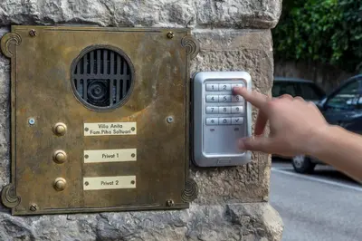 a person is pointing at a metal device on a stone wall at Apartments Villa Anita in Bolzano