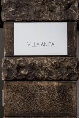 a sign on the side of a stone wall at Apartments Villa Anita in Bolzano