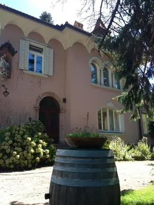 a house with a large barrel in front of it at Apartments Villa Anita in Bolzano