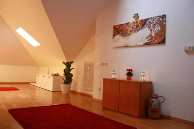 a living room with a red rug and a painting on the wall at Apartments Villa Anita in Bolzano