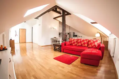 a living room with a red couch and a red rug at Apartments Villa Anita in Bolzano