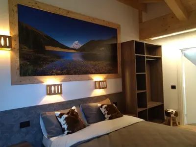 a bedroom with a large painting above a bed at Alpenrooms in Transacqua