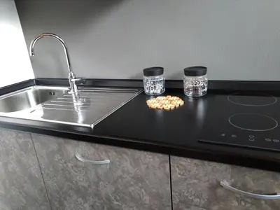a kitchen counter with two glasses and a sink at Alpenrooms in Transacqua