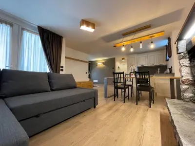a living room with a couch and a table with chairs at Alpenrooms in Transacqua