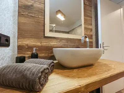 a bathroom with a white bowl sink on a wooden counter at Alpenrooms in Transacqua