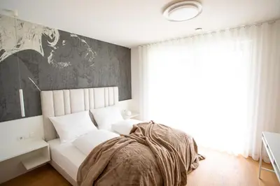 a bedroom with a white bed and a large window at Residenz Hofer in Naturno