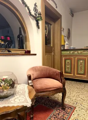 a brown chair sitting in a room with a table at Roter Adler in Caldaro