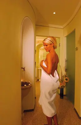 a woman in a white dress standing in a bathroom at Dolomitenhotel Weisslahnbad in Tires