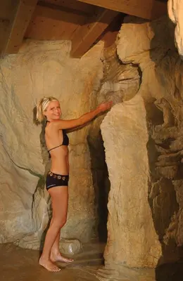 a woman in a bikini standing in the water at Dolomitenhotel Weisslahnbad in Tires