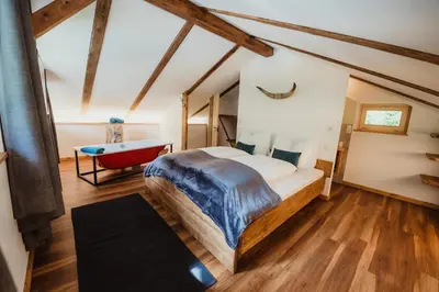 a bedroom with a large bed and a bathtub at Chalet Passeier - RIVER in Saltusio