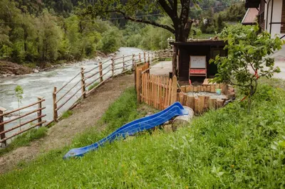 a water slide in the grass next to a river at Chalet Passeier - RIVER in Saltusio