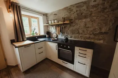 a kitchen with white cabinets and a black stove top oven at Chalet Passeier - RIVER in Saltusio