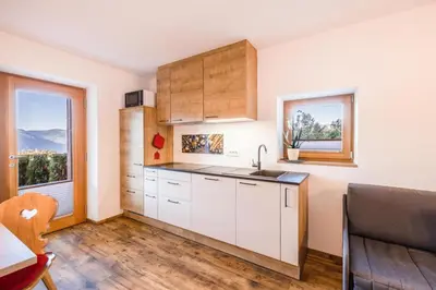 a kitchen with white cabinets and a window at Gfliererhof in Fiè