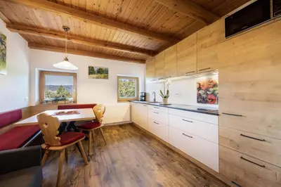 a kitchen with white cabinets and a wooden ceiling at Gfliererhof in Fiè