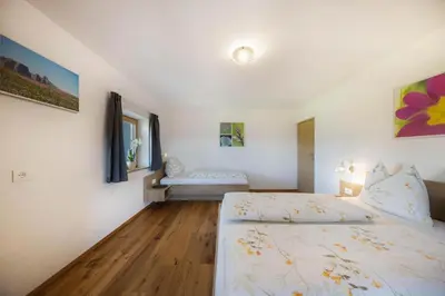 a bedroom with a bed and a couch in it at Gfliererhof in Fiè